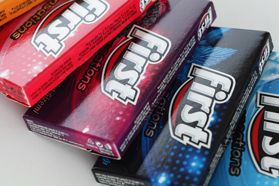 First Sensations packs close up, in red, dark and blue, with the First logo and its red swoosh